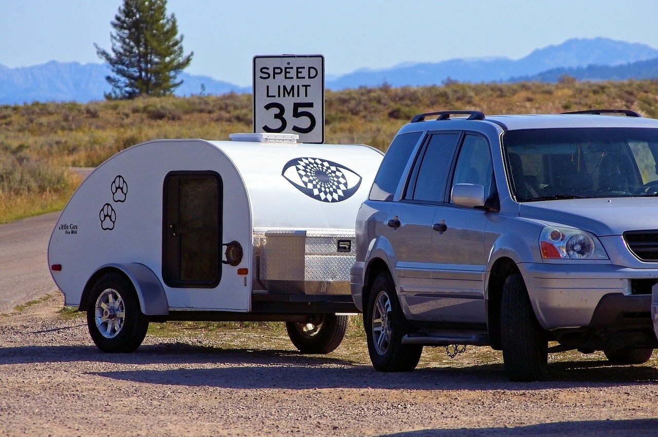 Teardrop trailer towed by a small SUV