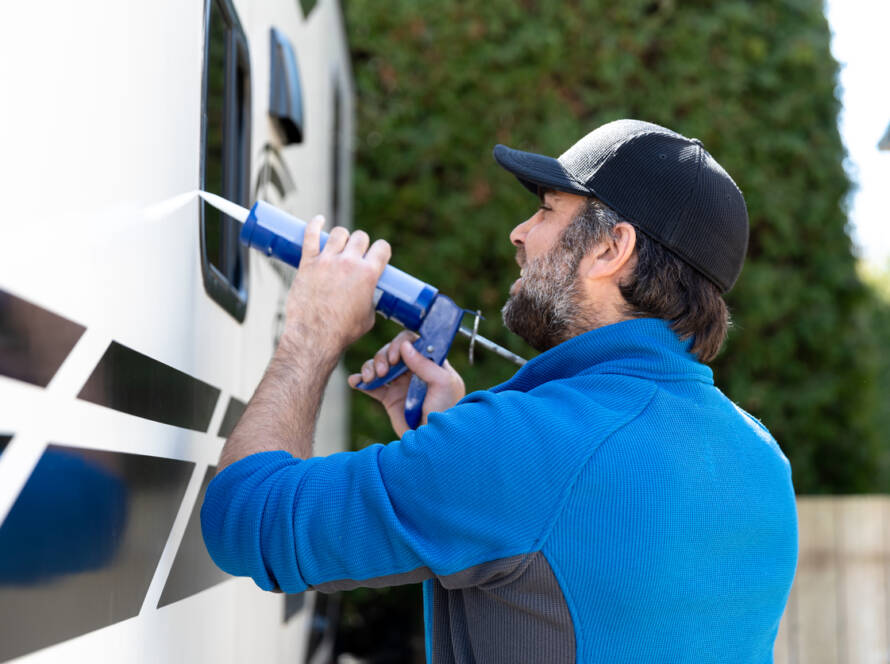 Man Doing Maintenance of Camper Trailer